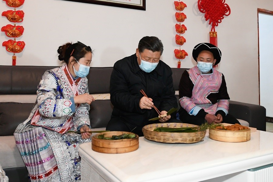 2021年2月3日下午，習近平在貴州畢節(jié)市黔西縣新仁苗族鄉(xiāng)化屋村苗族村民趙玉學家，同一家人邊聊家常邊制作當?shù)貍鹘y(tǒng)節(jié)日食品黃粑。新華社記者 李學仁 攝